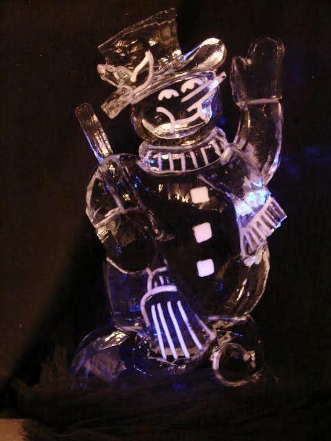 A clear glass snowman with a top hat and scarf