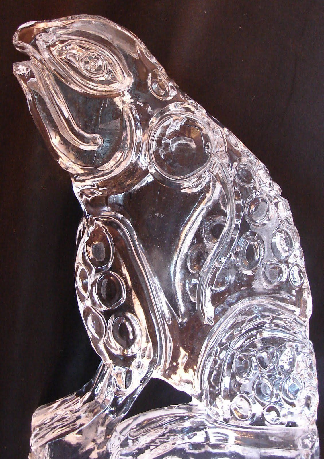 A clear glass frog with its mouth open