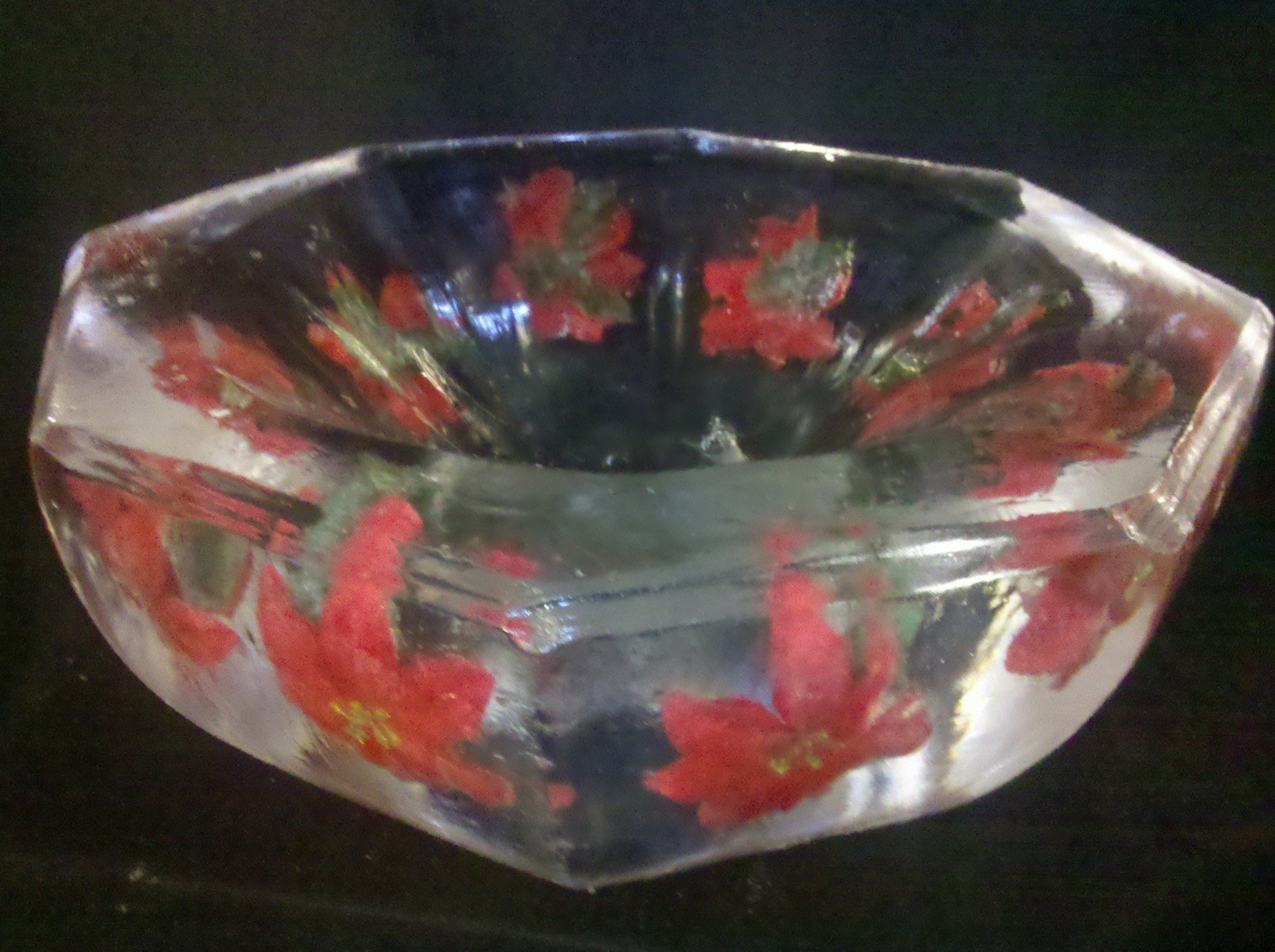 A clear bowl with red flowers on it