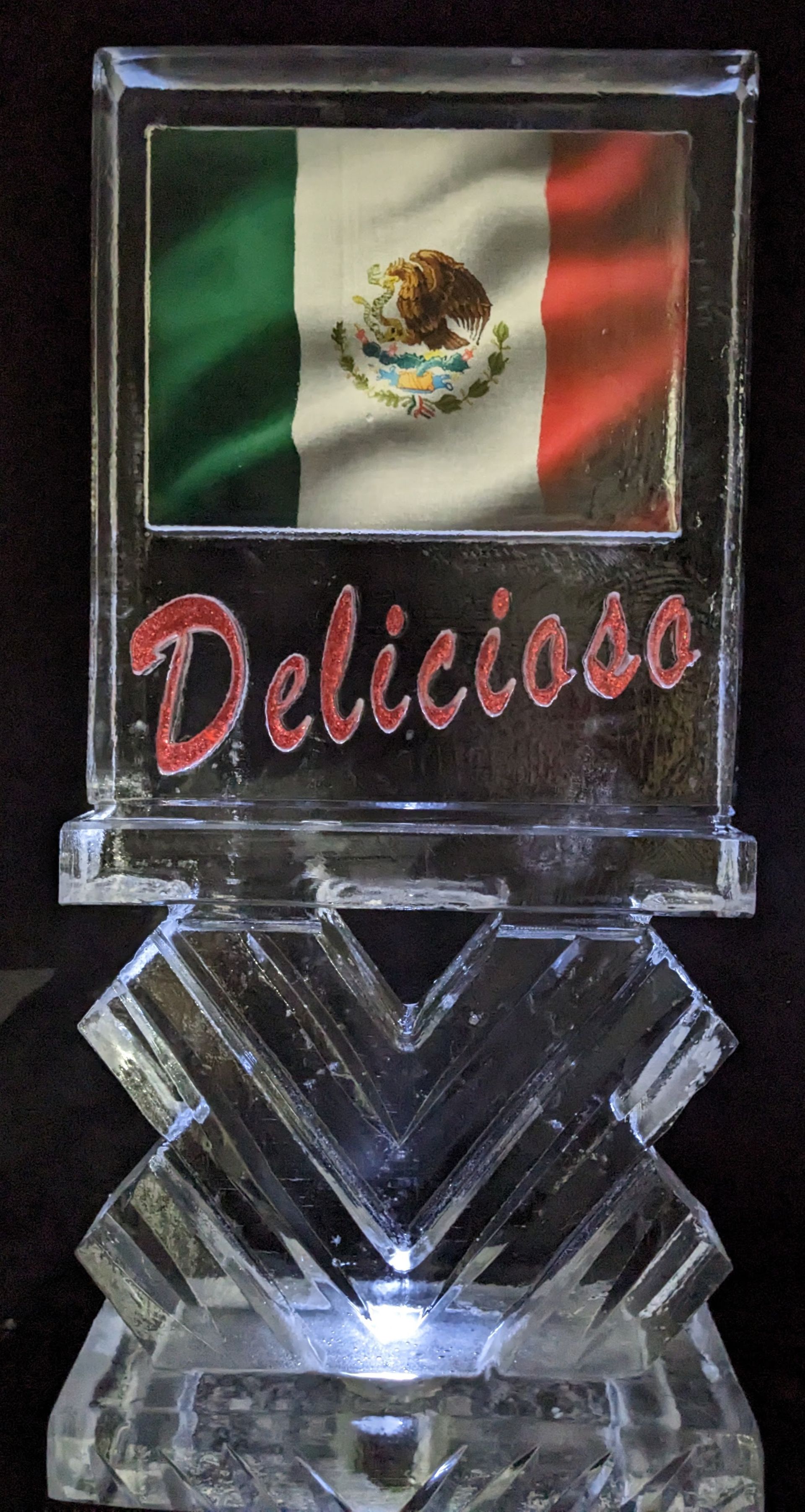 An ice sculpture with a mexican flag and the word delicioso on it
