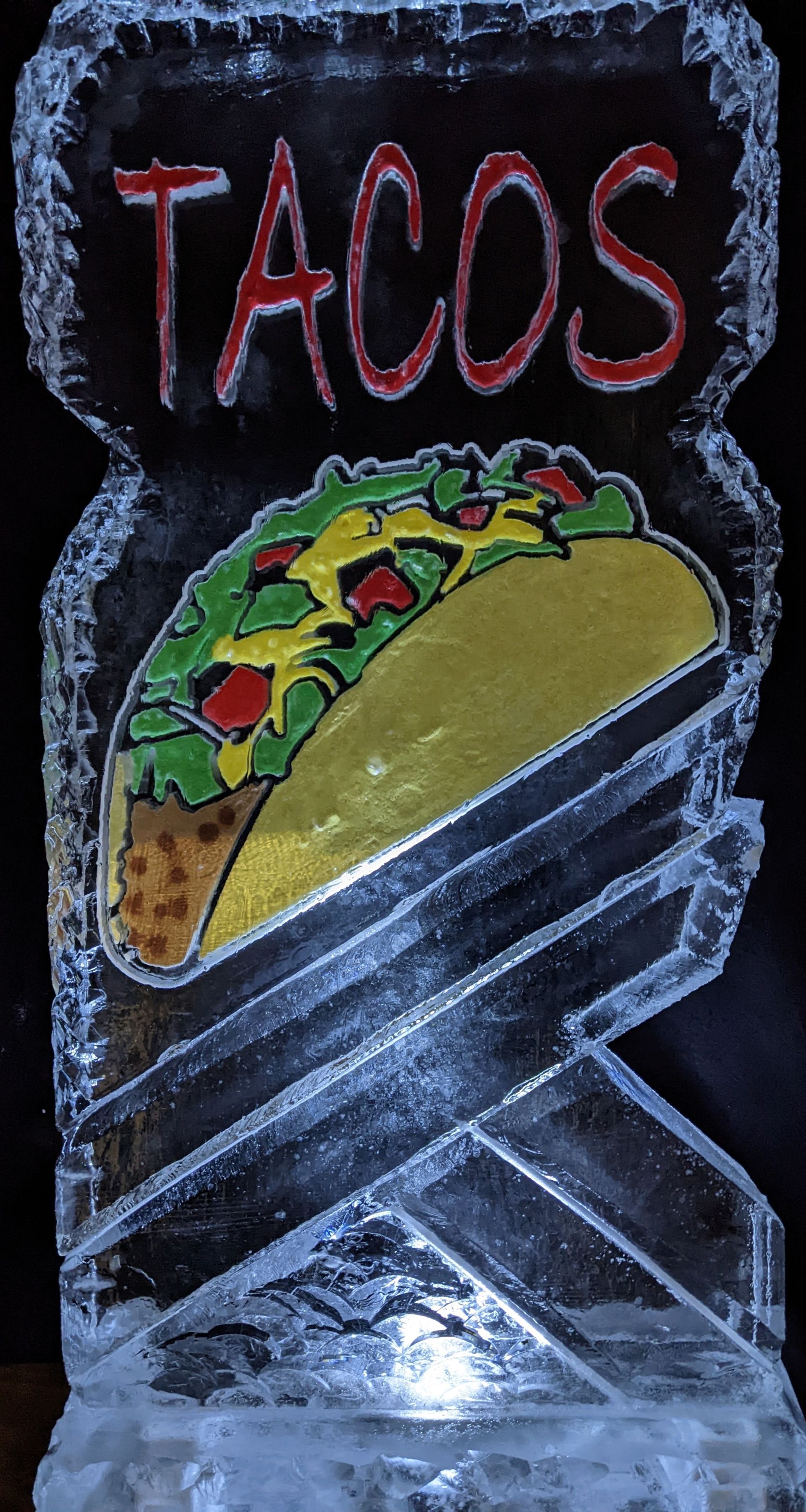 An ice sculpture of a taco with the word tacos on it