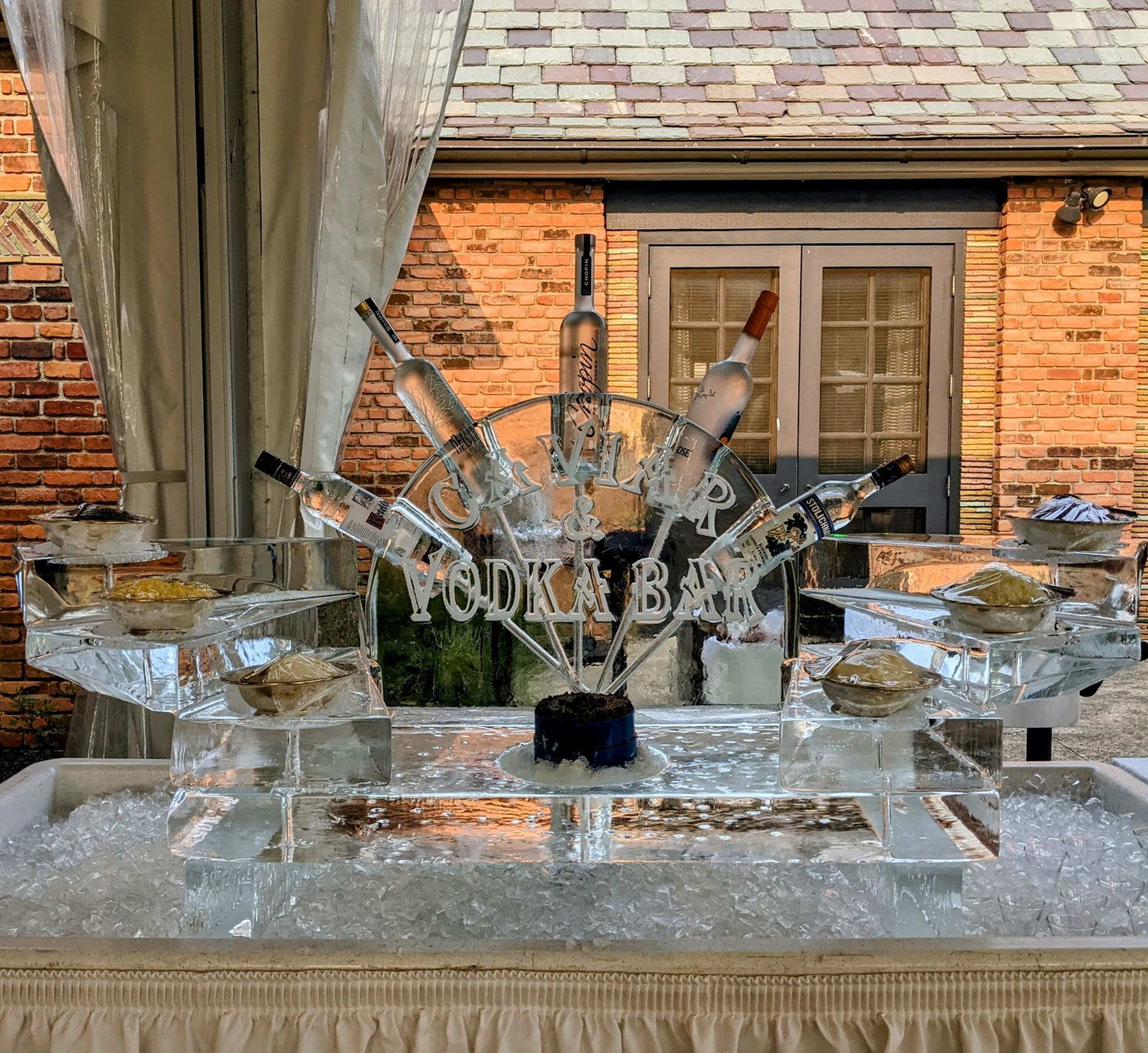 A table with ice sculptures of wine bottles and a steering wheel.