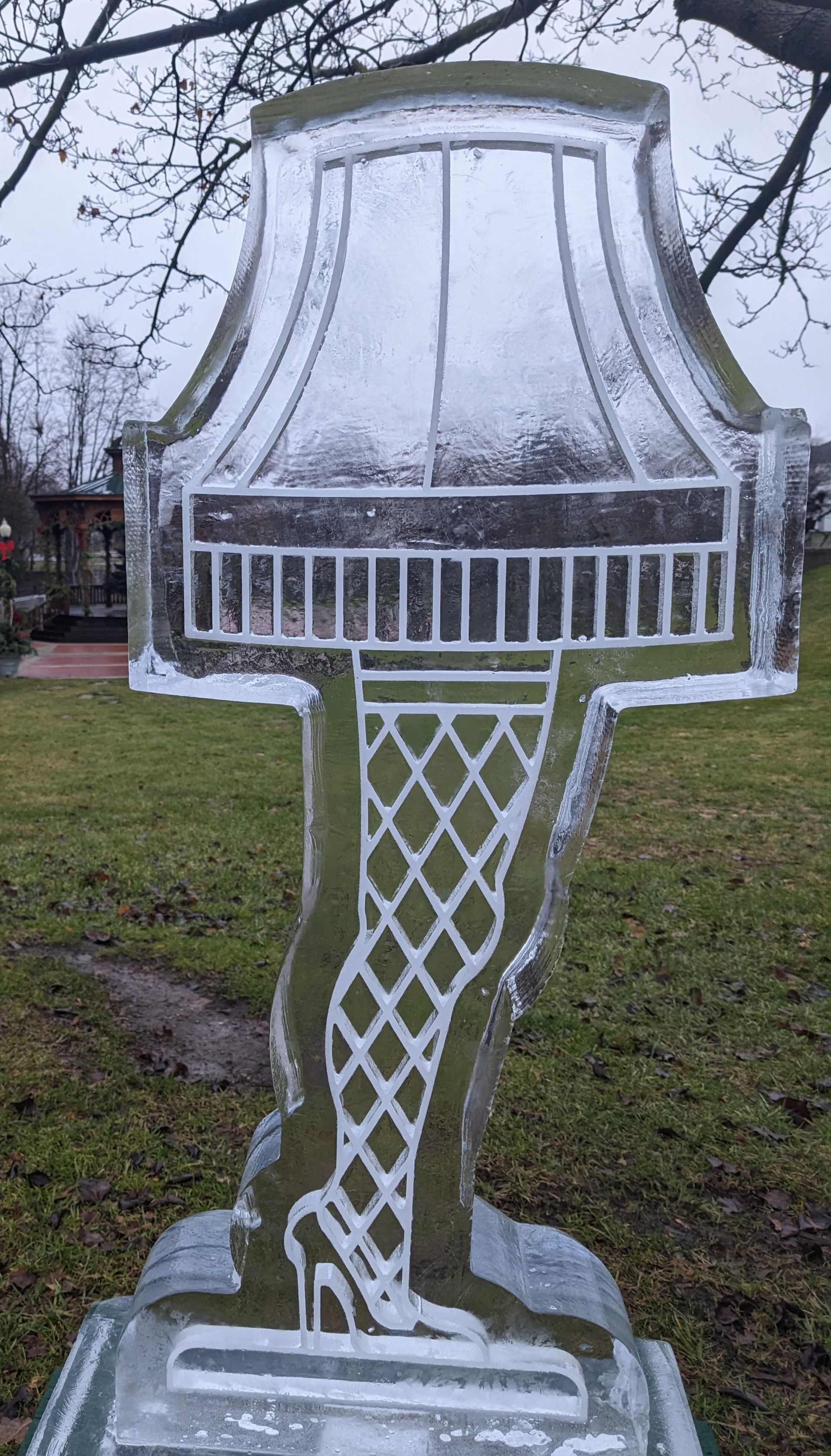 An ice sculpture of a lamp with a woman 's leg in high heels.