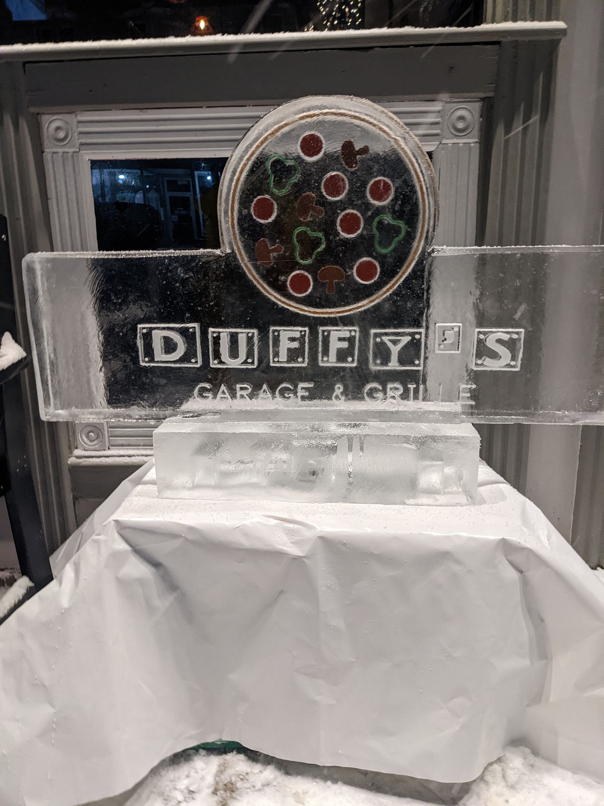 A large ice sculpture of a pizza is sitting on top of a table.