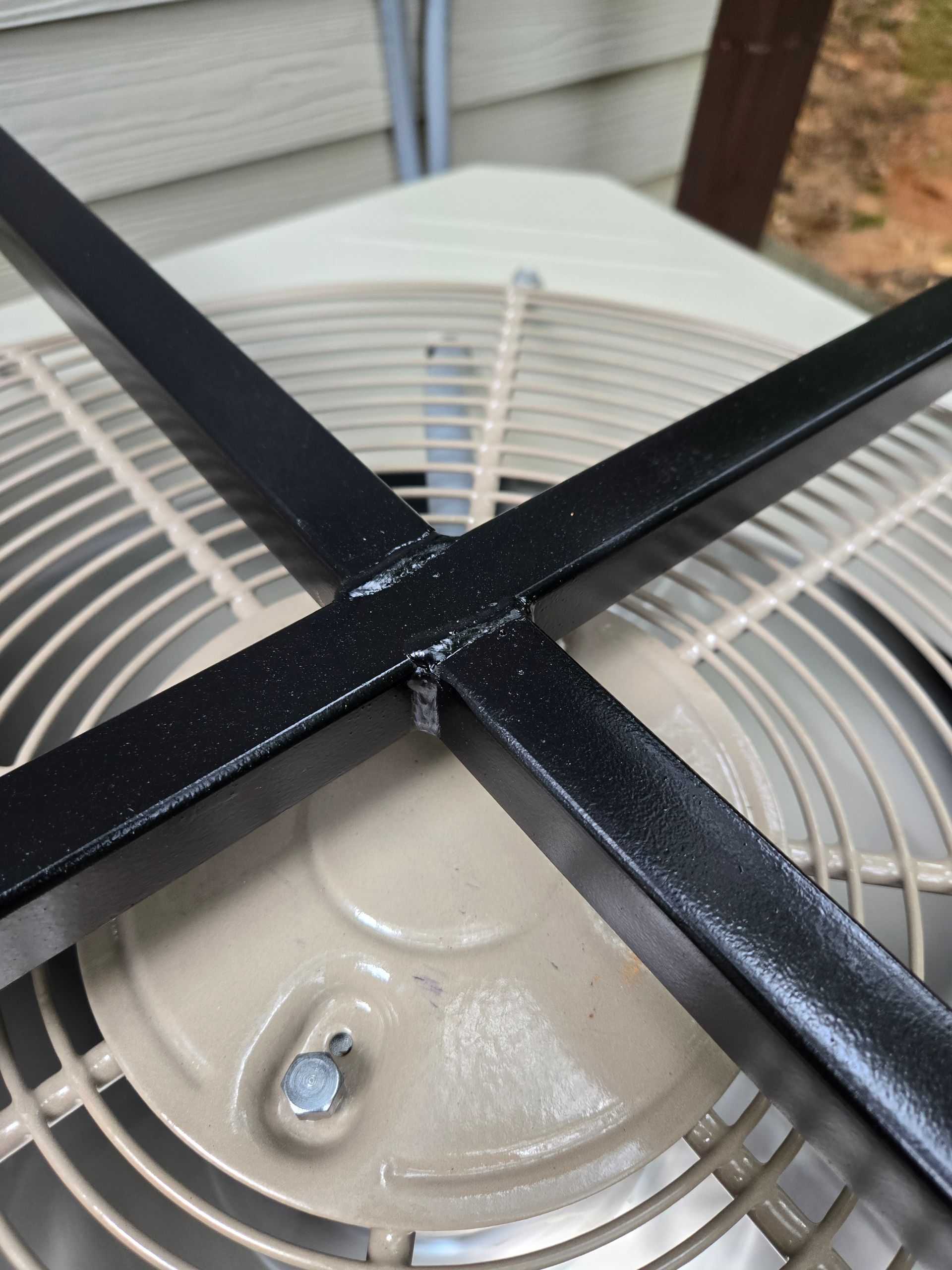 A close up of a fan with a black frame on top of it.