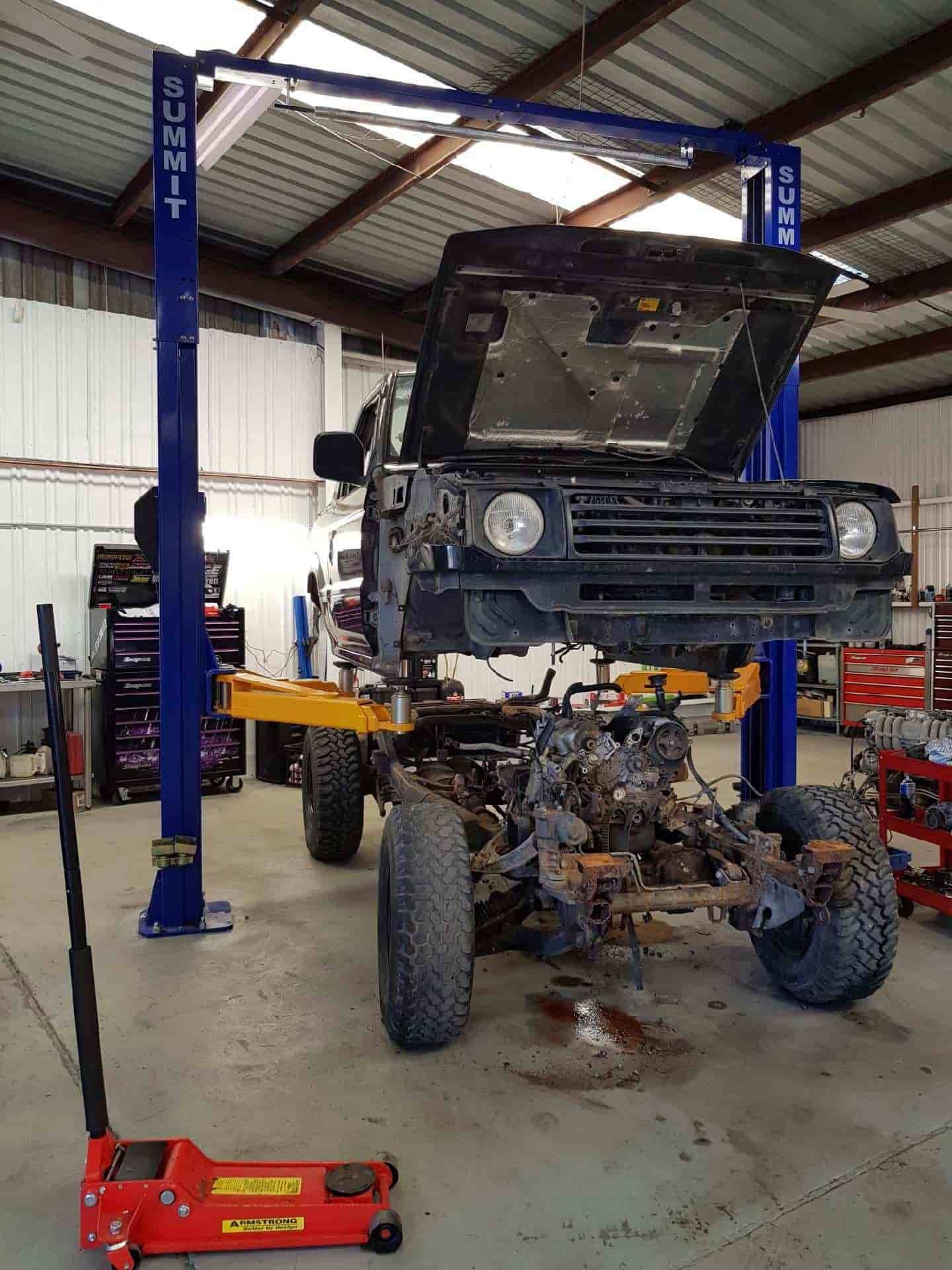 A Truck Is Sitting On A Lift In A Garage — Sojos Mechanical & Tyre Service In Wyoming, NSW