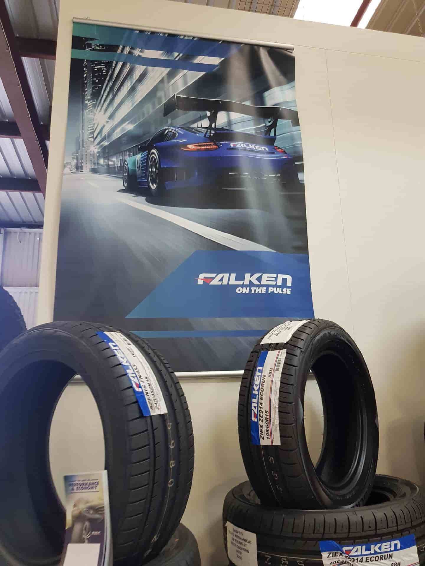 A Poster Of A Car Is Hanging On A Wall Next To A Pile Of Tires — Sojos Mechanical & Tyre Service In Wyoming, NSW
