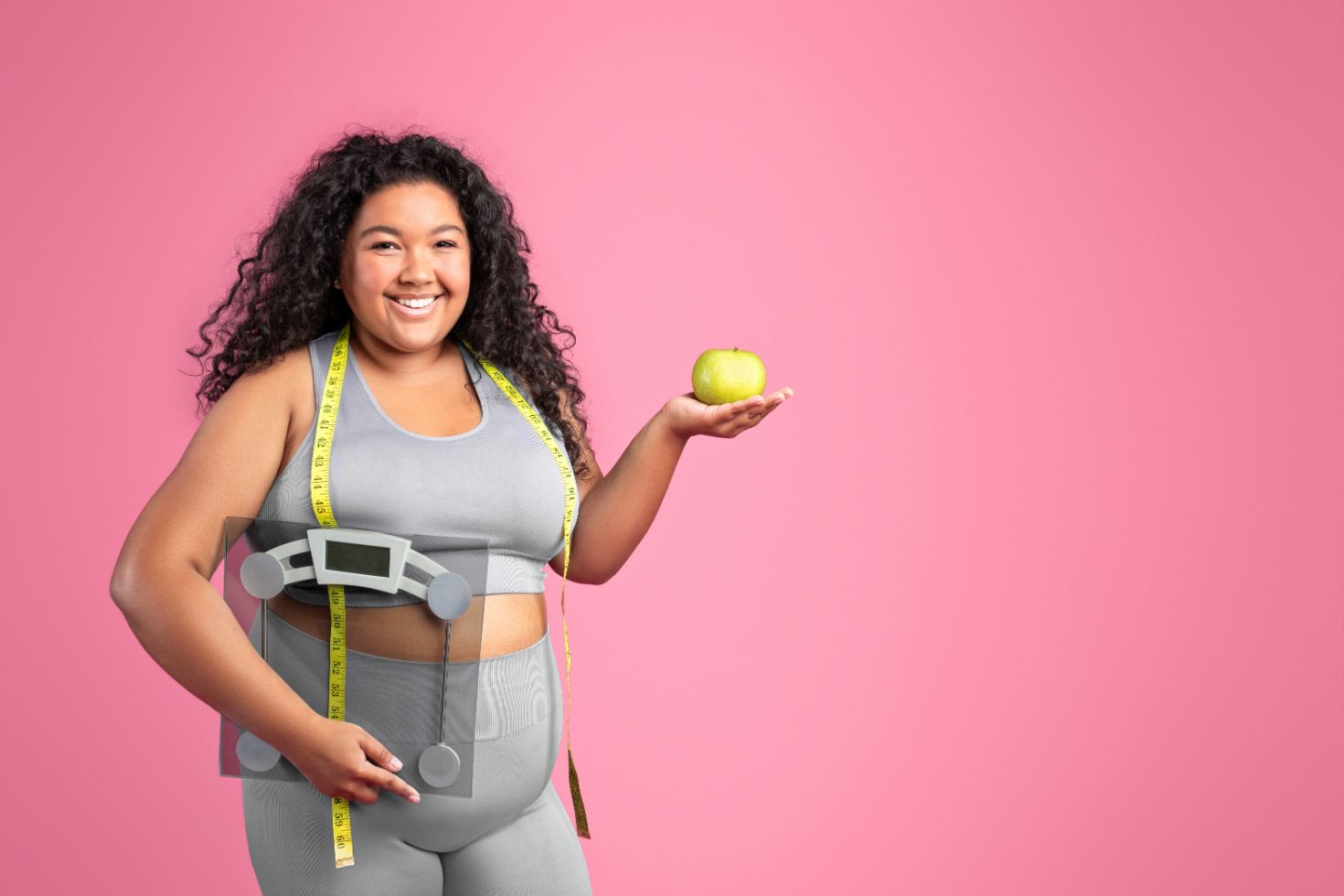 A Woman Is Measuring Her Waist and Holding an Apple — Great Bends, KS — Innovative Wellness A Woman Is Measuring Her Waist and Holding an Apple — Great Bends, KS — Innovative Wellness