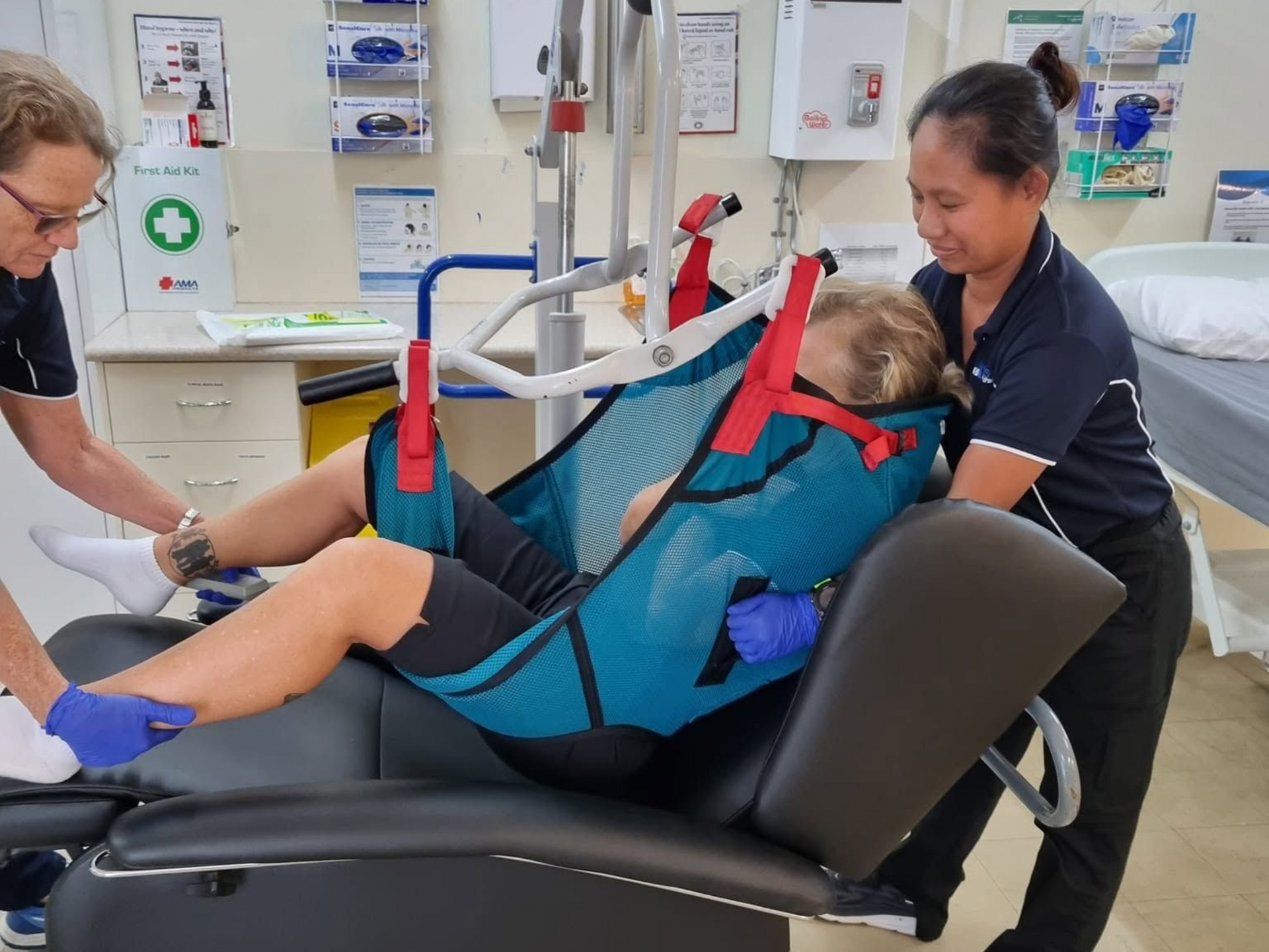 Patient on a Transfer Lift Being Assisted by Two Healthcare Workers — Accredited Training in Rockhampton QLD
