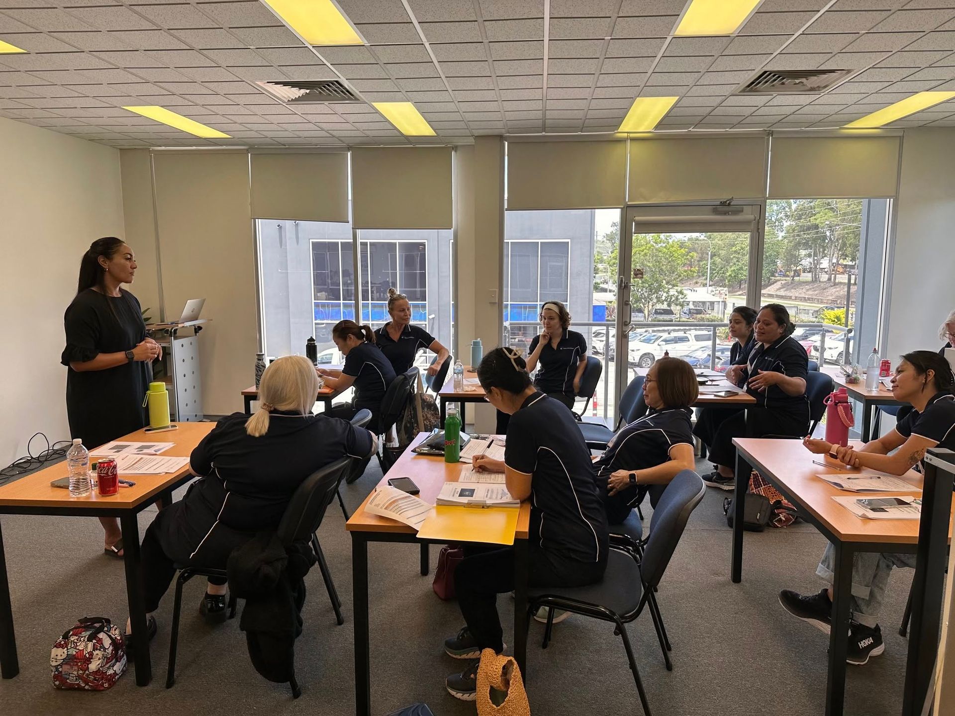 Meeting in a Bright Office Classroom, People Seated at Tables Listening — Accredited Training in Rockhampton QLD