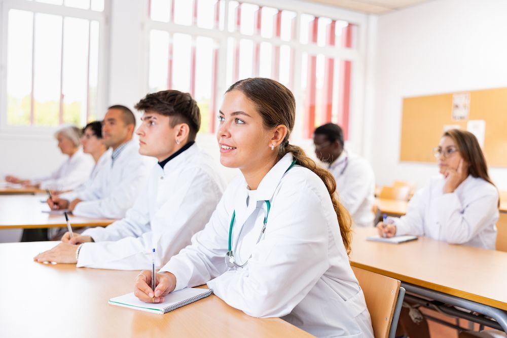 Students in White Uniforms Seated at Desks in a Bright Classroom — Blue Stone Medical & Professional in West Rockhampton, QLD