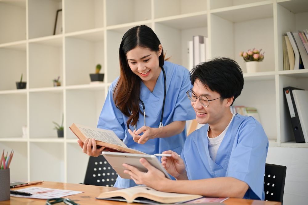 Two Coworkers in Blue Shirts Reviewing a Tablet at a Desk — Blue Stone Medical & Professional in West Rockhampton, QLD