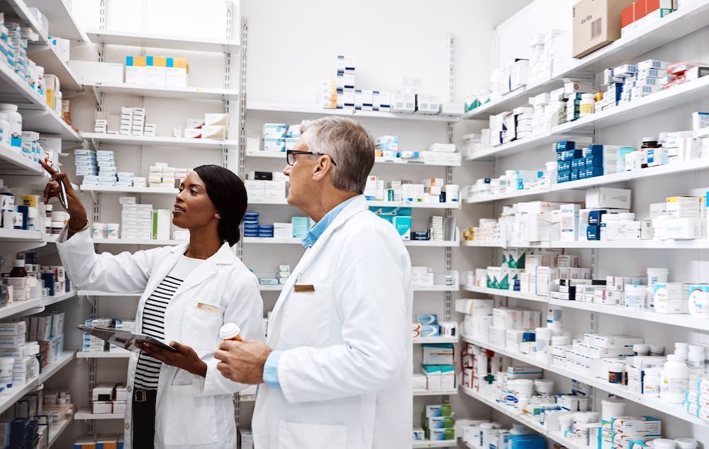 Two Pharmacists in White Coats Discuss Prescriptions — Blue Stone Medical & Professional in West Rockhampton, QLD