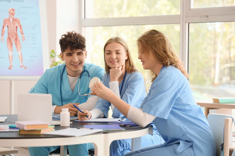 Three Medical Students in Blue Scrubs Discussing Notes — Blue Stone Medical & Professional in West Rockhampton, QLD