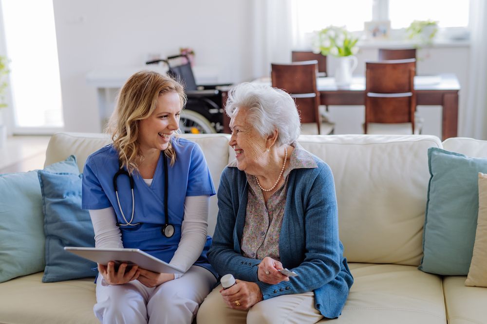 Healthcare Worker Talking With a Smiling Older Patient — Blue Stone Medical & Professional in West Rockhampton, QLD