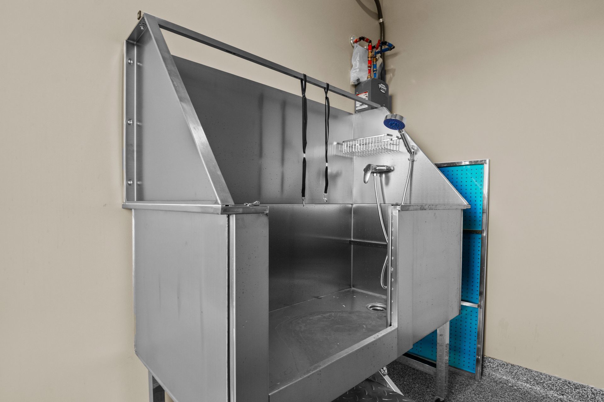 A man is washing a black dog in a bathtub.