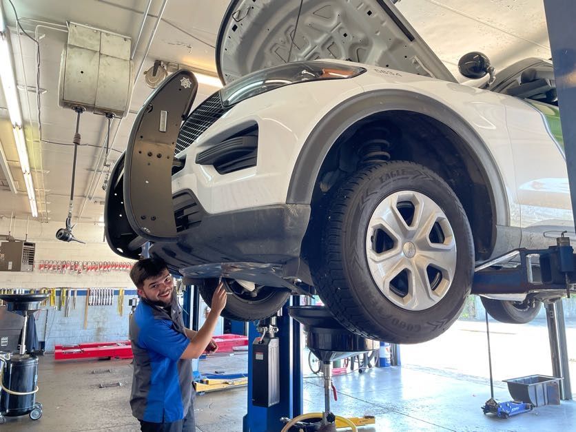 Technician performing routine maintenance on a vehicle