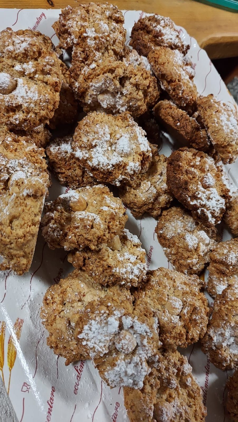 un primo piano di un piatto di biscotti con zucchero a velo sopra.