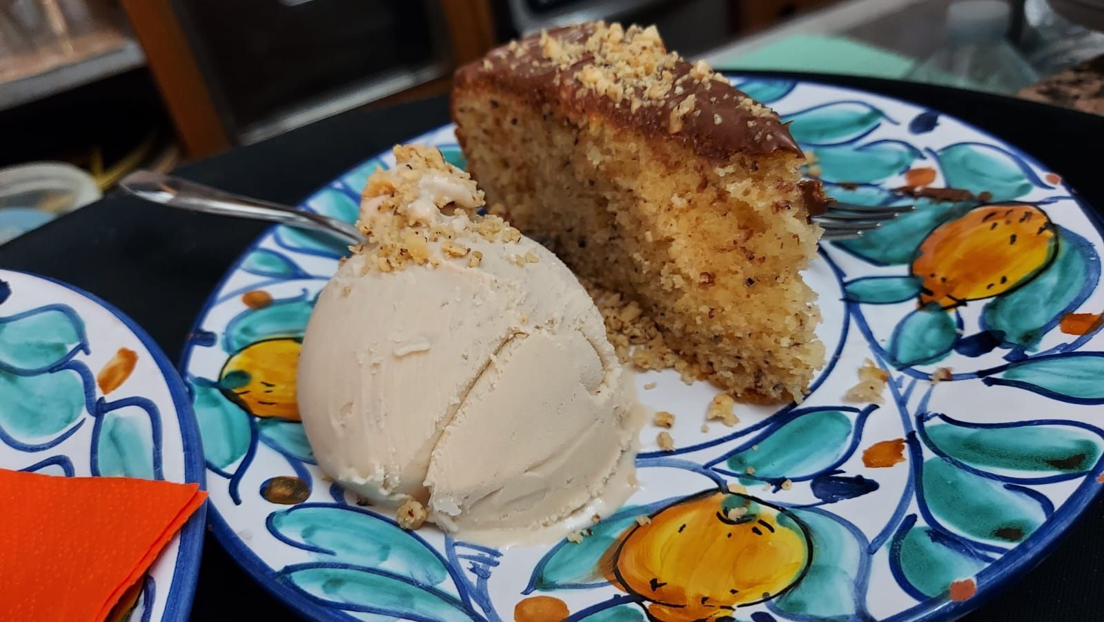 una fetta di torta e una pallina di gelato su un piatto.