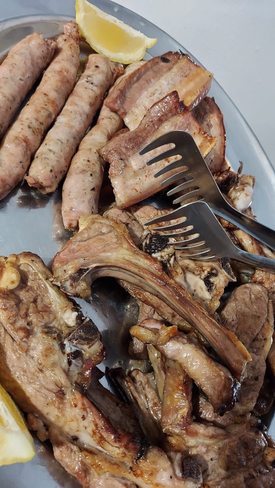 un piatto di carne e salsicce con sopra una forchetta.