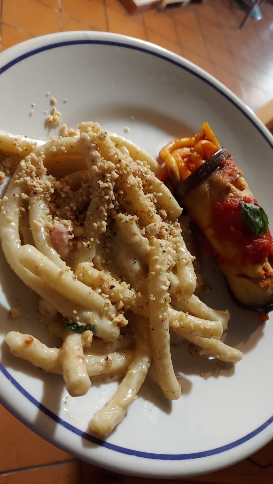 un piatto di pasta e un panino su un tavolo.