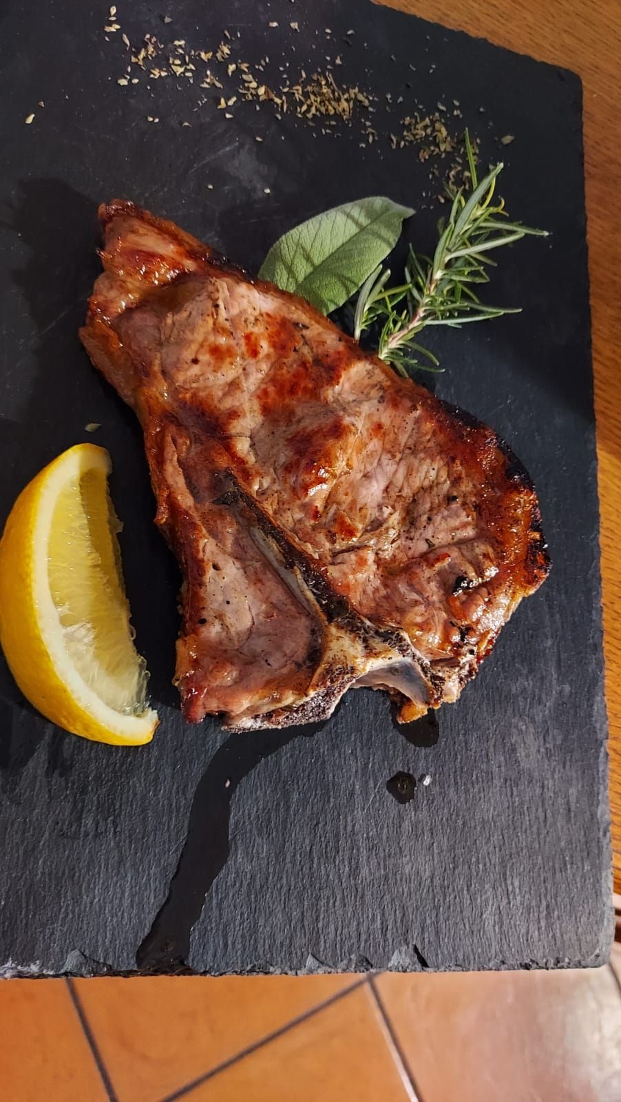 un pezzo di carne con accanto una fetta di limone