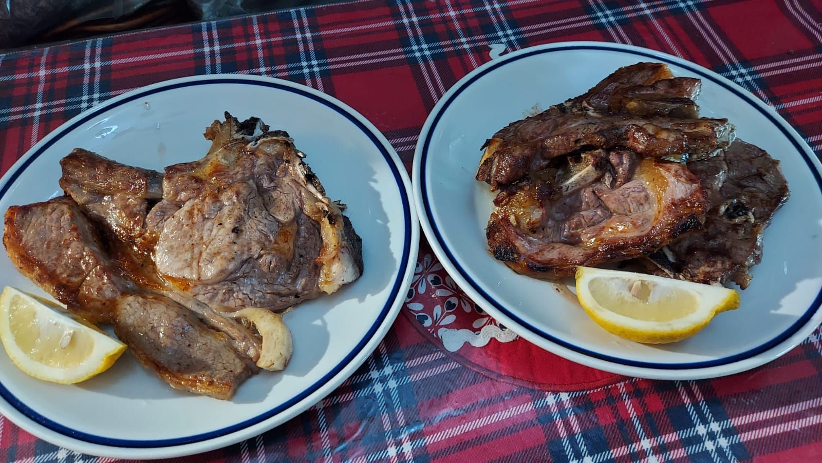 due piatti di carne con fette di limone su un tavolo