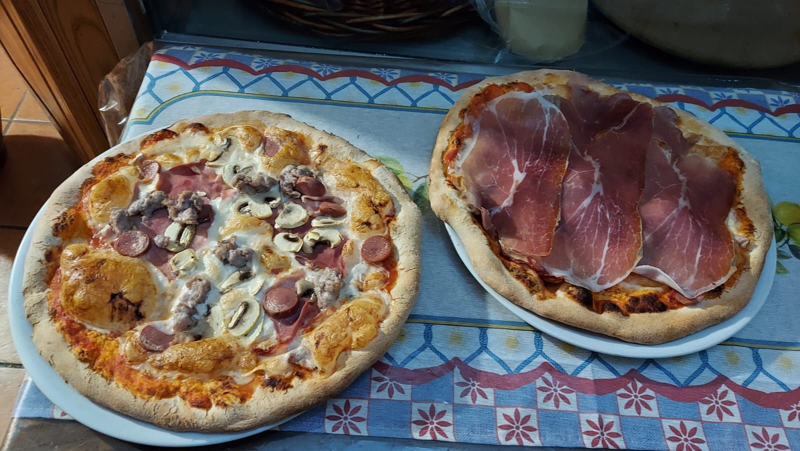 due pizze sui piatti su un tavolo.