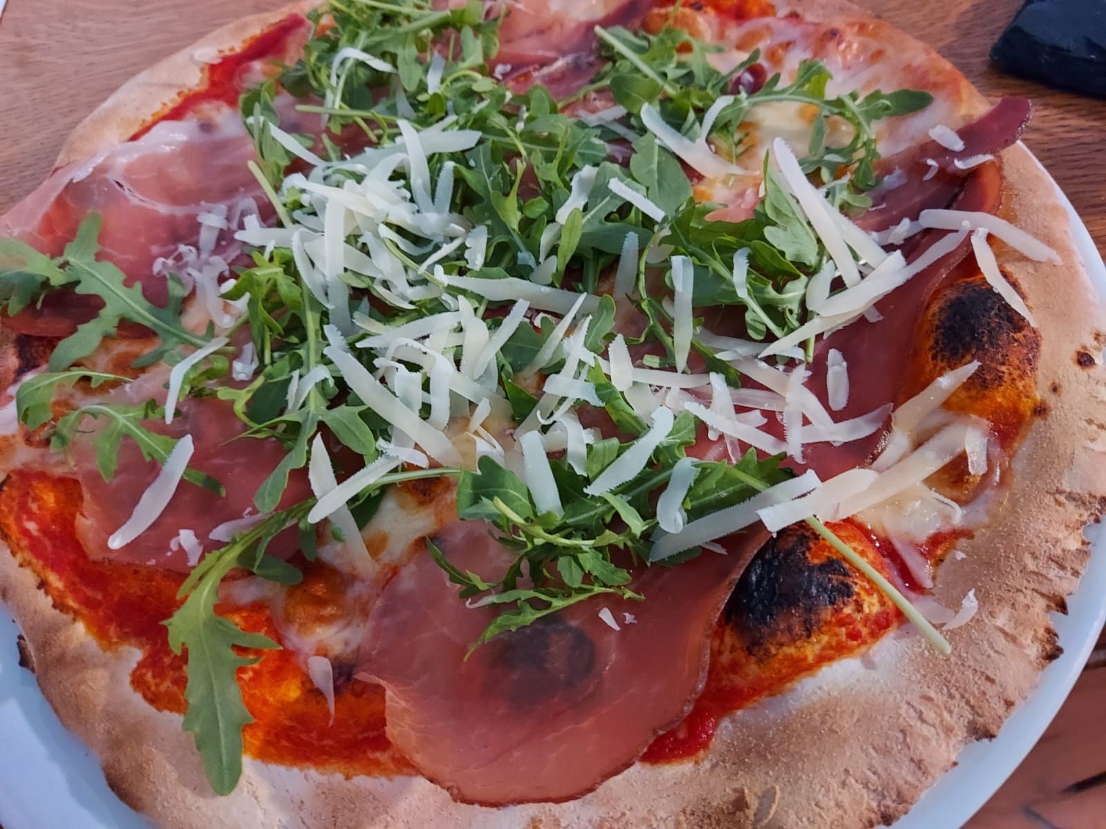 su un piatto c'è una pizza con molti condimenti.