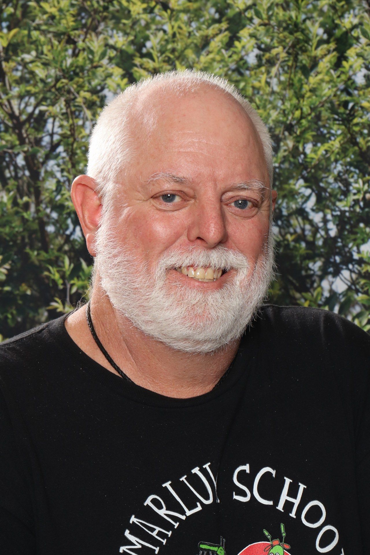 A man with a beard is wearing a colorful shirt with animals on it