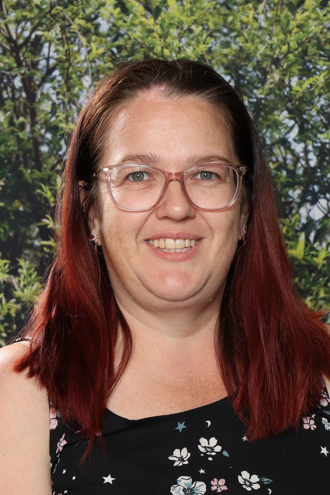 A woman in a striped shirt is smiling for the camera.