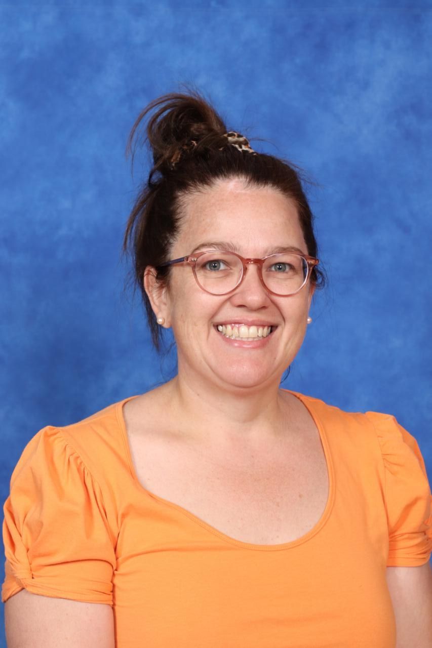 A woman in a striped shirt is smiling for the camera.