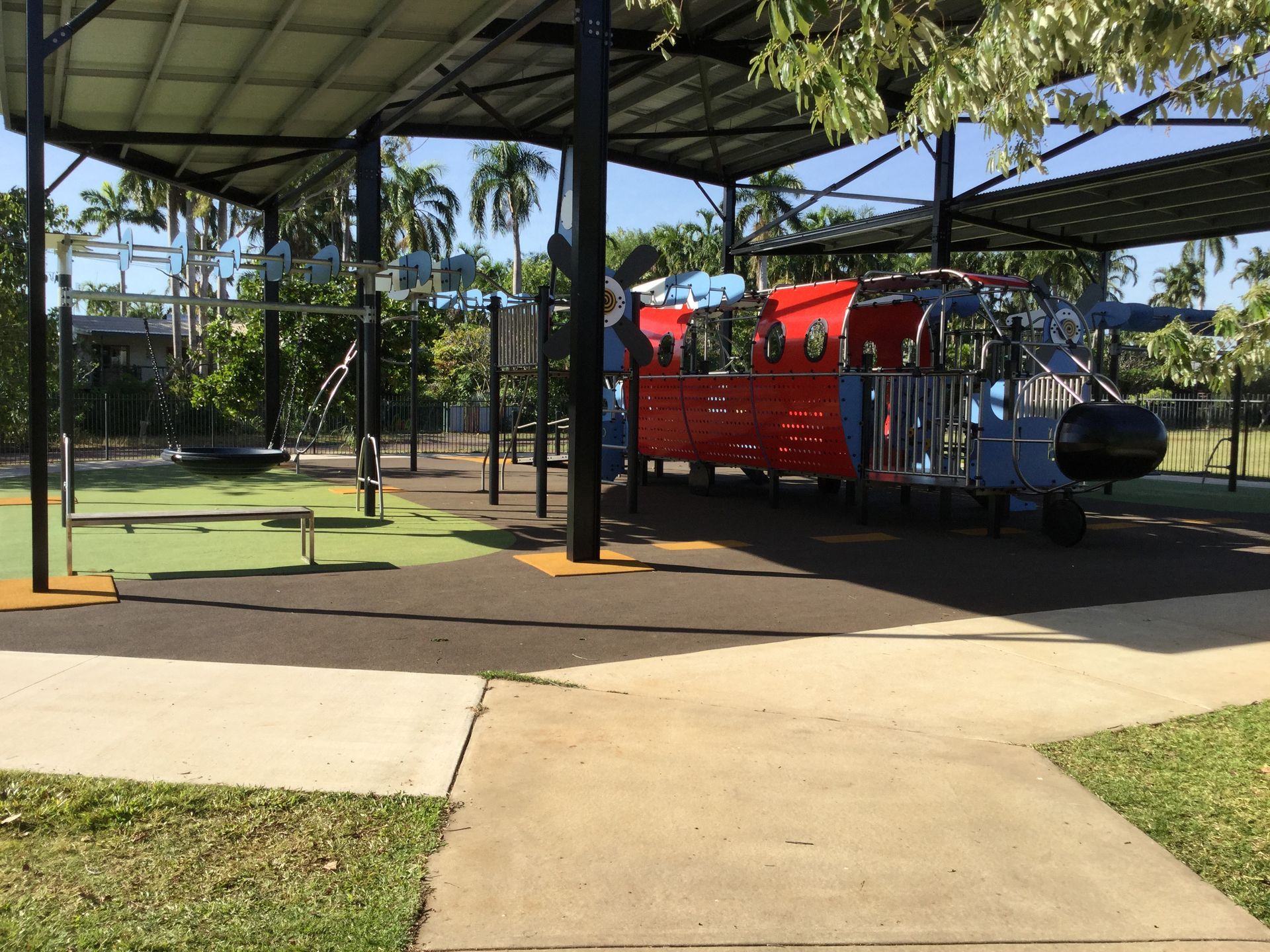 A playground with a red train in the middle of it