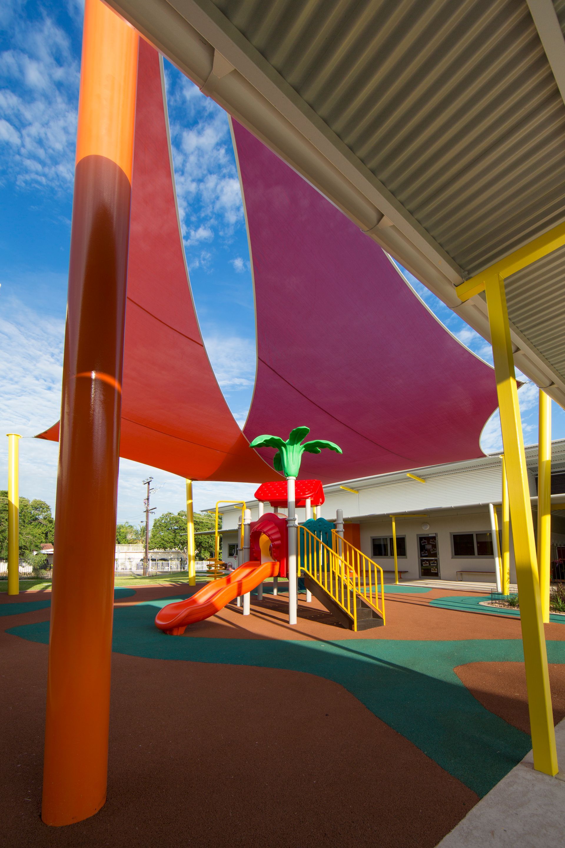 A playground with a red sail and a slide