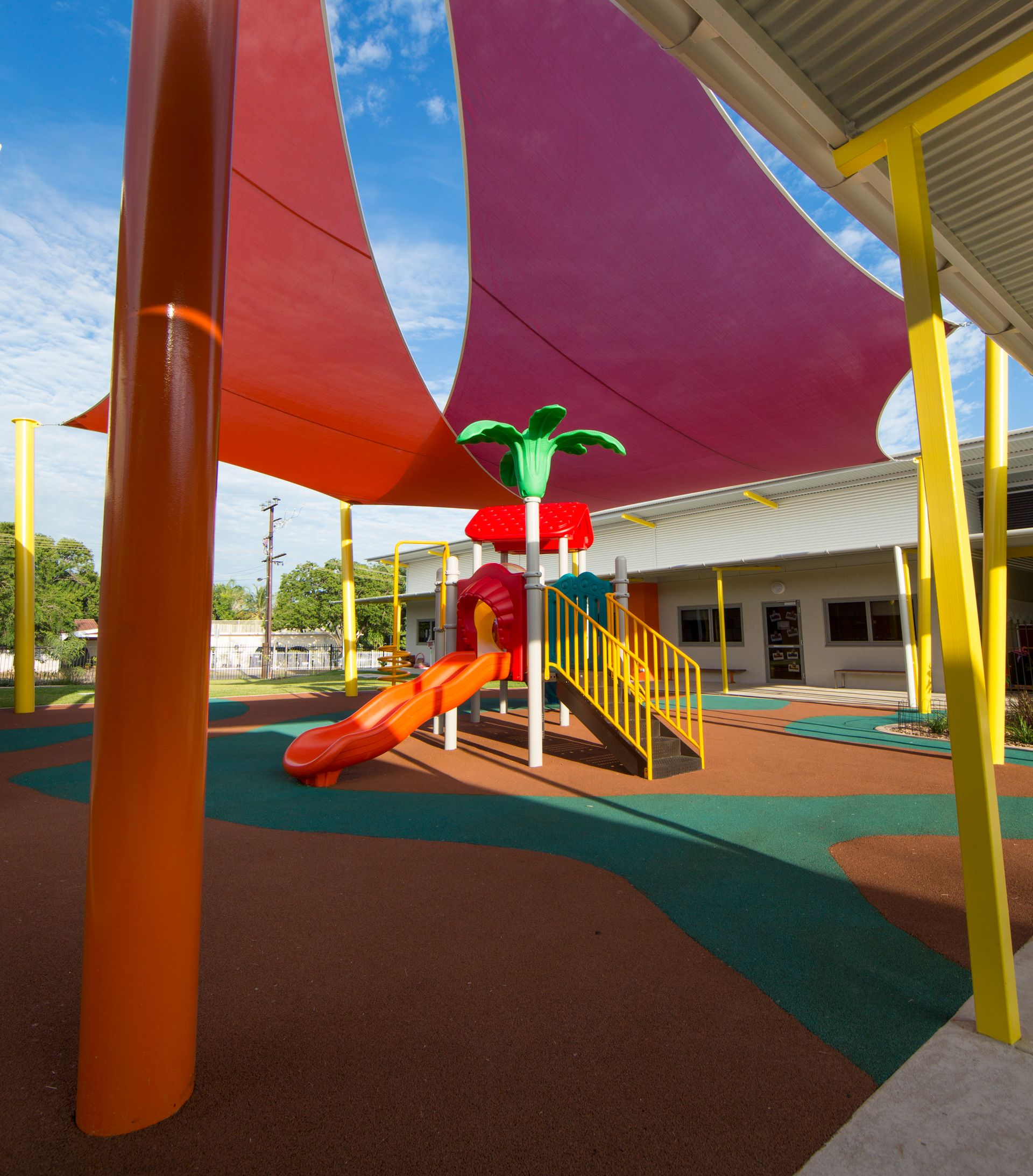 A playground with a red sail and a slide
