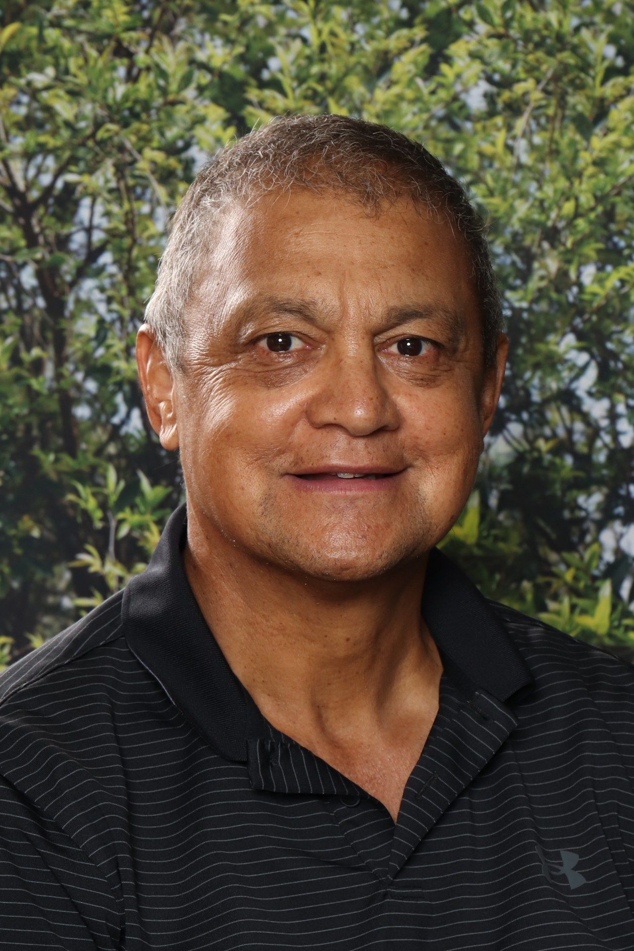 A man in a blue shirt is smiling for the camera.