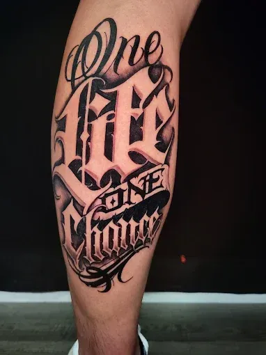 Tattoo on a leg that reads 