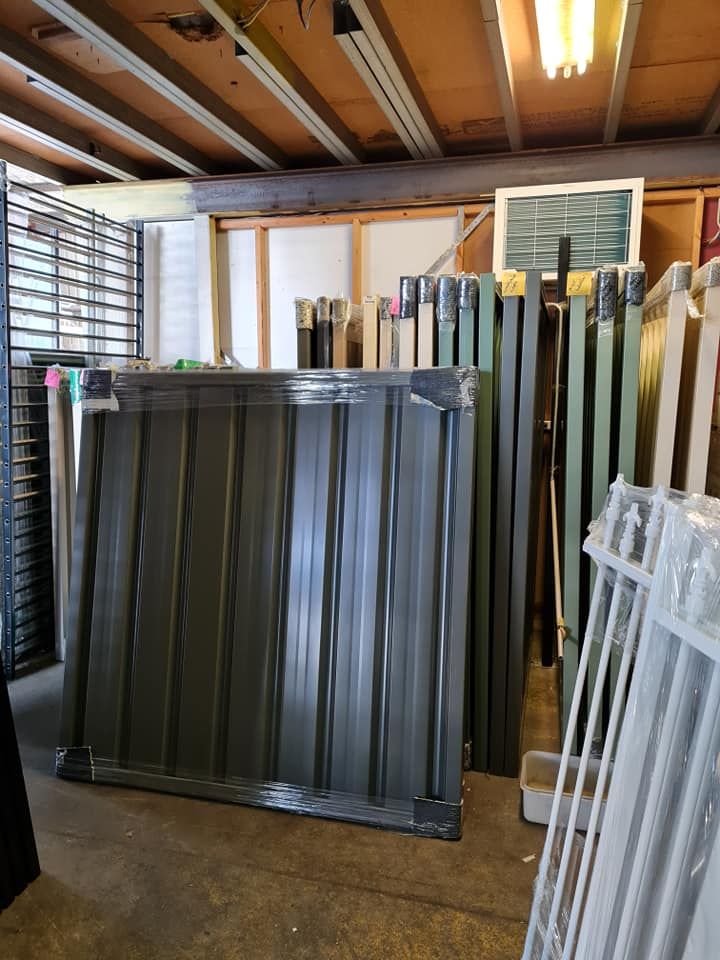 Metal Fence Panels Stacked in a Storage Room With Various Other Fence Parts — Metal Fencing Supplies In Wingham, NSW