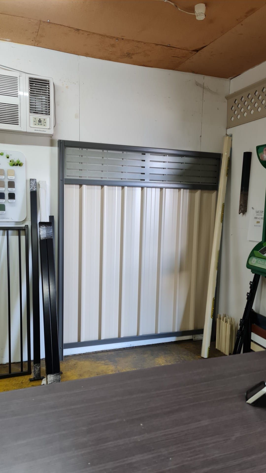 A Sliding Metal Gate With Corrugated Panels Inside a Room, Along — Metal Fencing Supplies In Old Bar, NSW