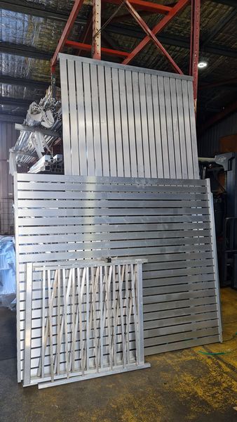 Various Sized, Metallic Silver, Metal Fence Panels Stacked Together — Metal Fencing Supplies In Old Bar, NSW