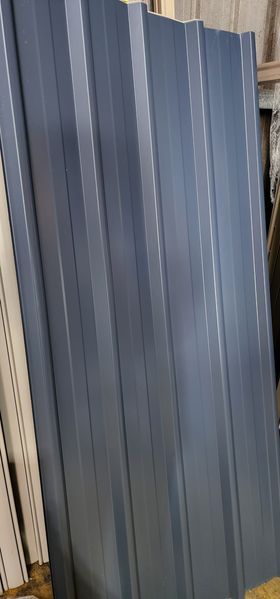 Grey Corrugated Metal Panels Stacked Against a Wall — Metal Fencing Supplies In Taree, NSW