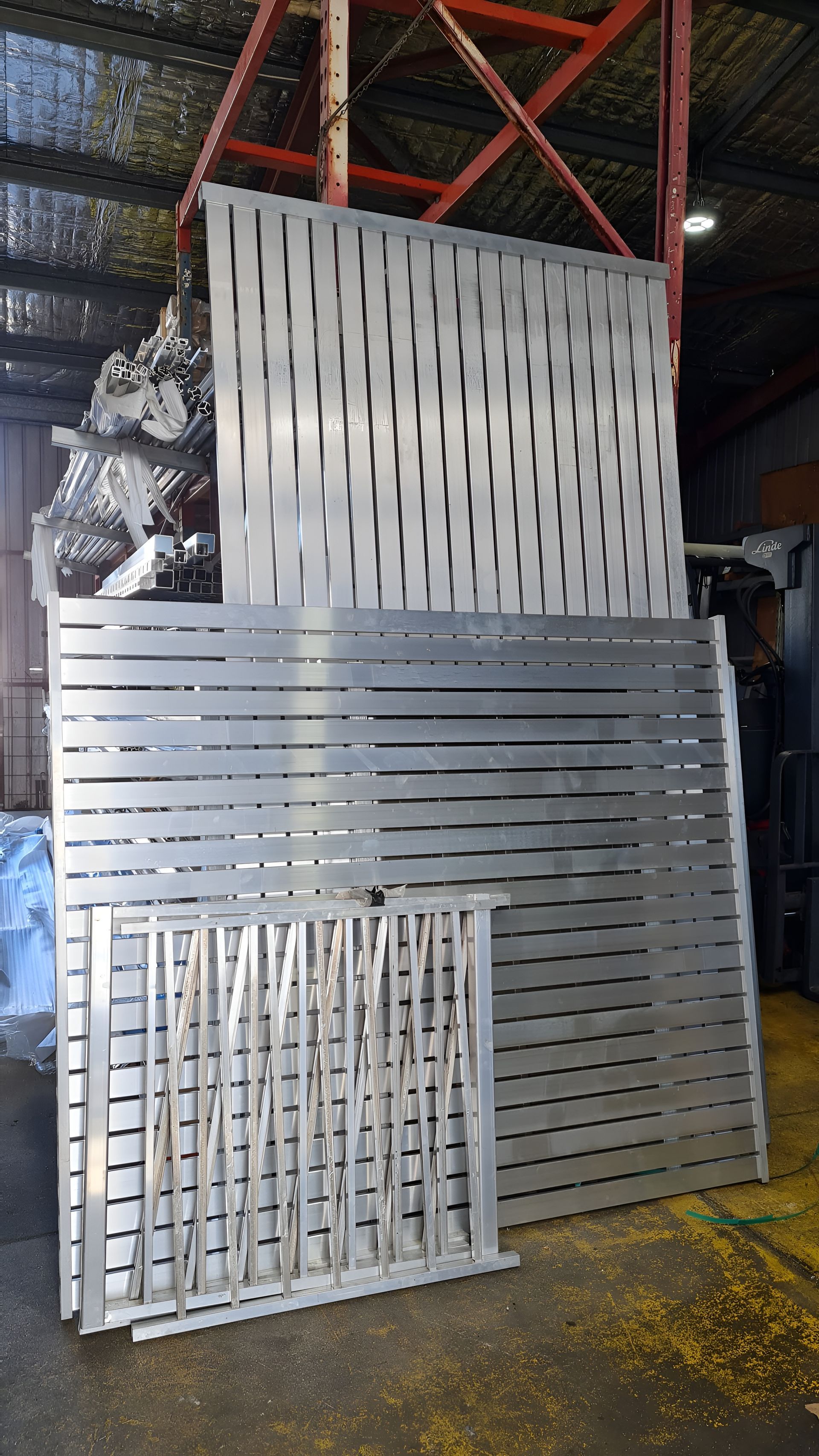 Stacks of Metal Fence Panels in a Warehouse, Varying in Size and Design — Metal Fencing Supplies In Taree, NSW