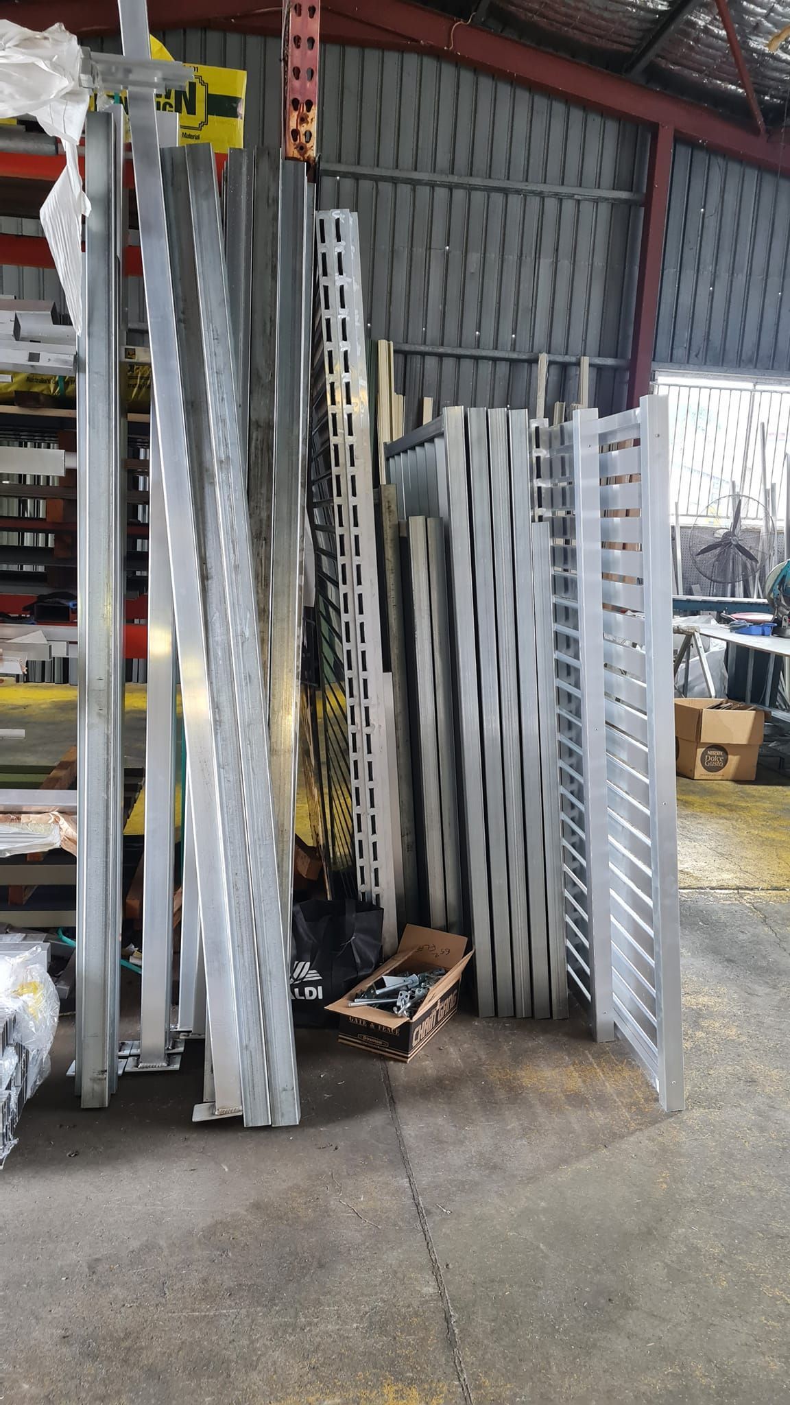 Metal Shelving Components Leaning Against a Wall in a Warehouse — Metal Fencing Supplies In Old Bar, NSW