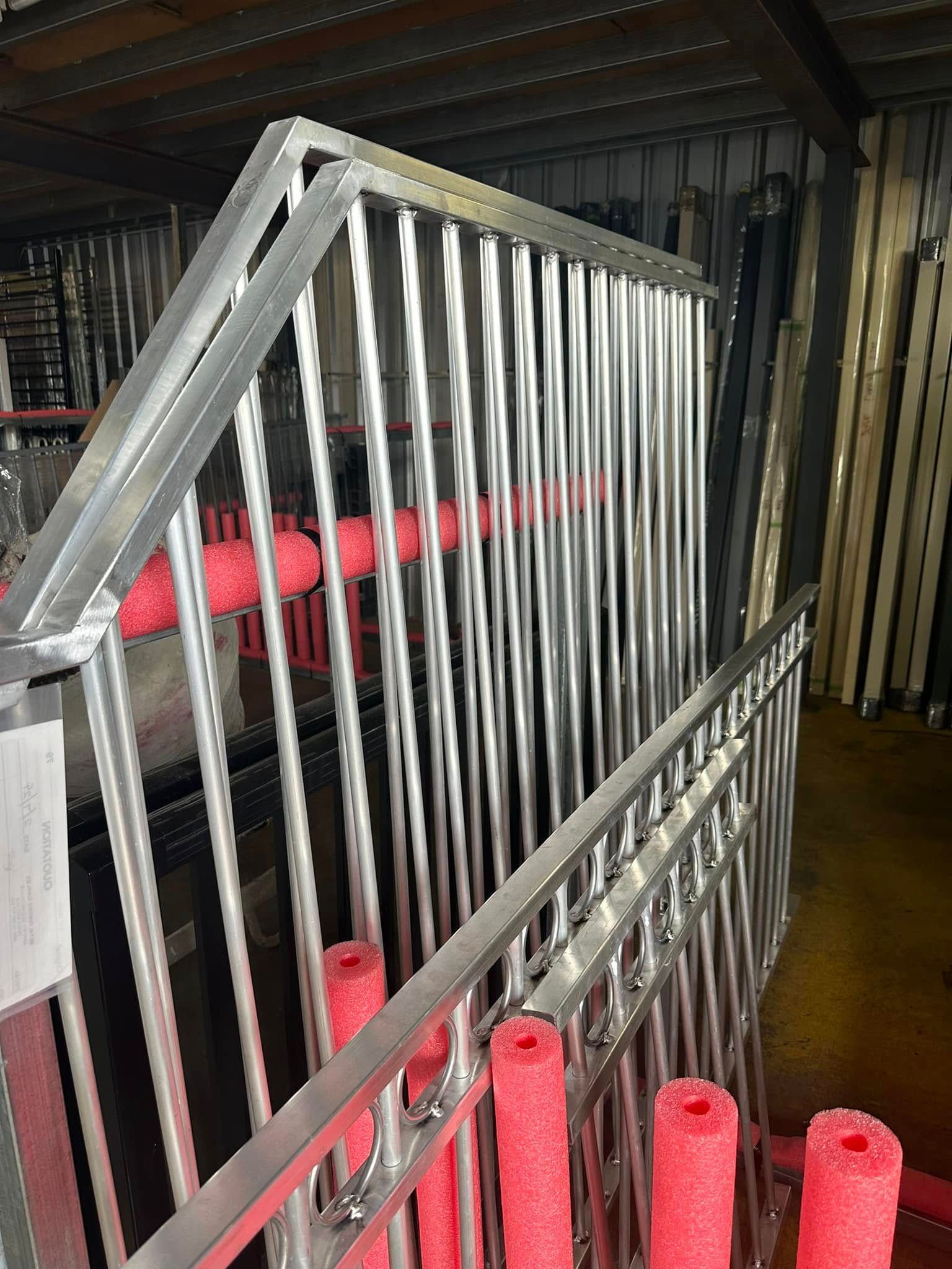 Metal Crowd Control Barriers Stacked Indoors With Red Foam Bumpers — Metal Fencing Supplies In Forster, NSW