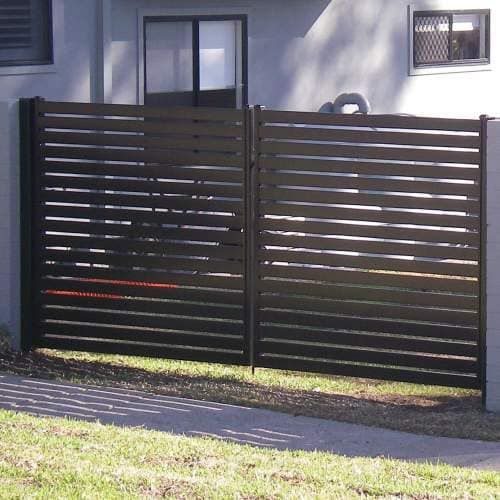 Black Horizontal Slat Gate in Front of a Building With a Window and Grassy Area — Metal Fencing Supplies In Taree, NSW