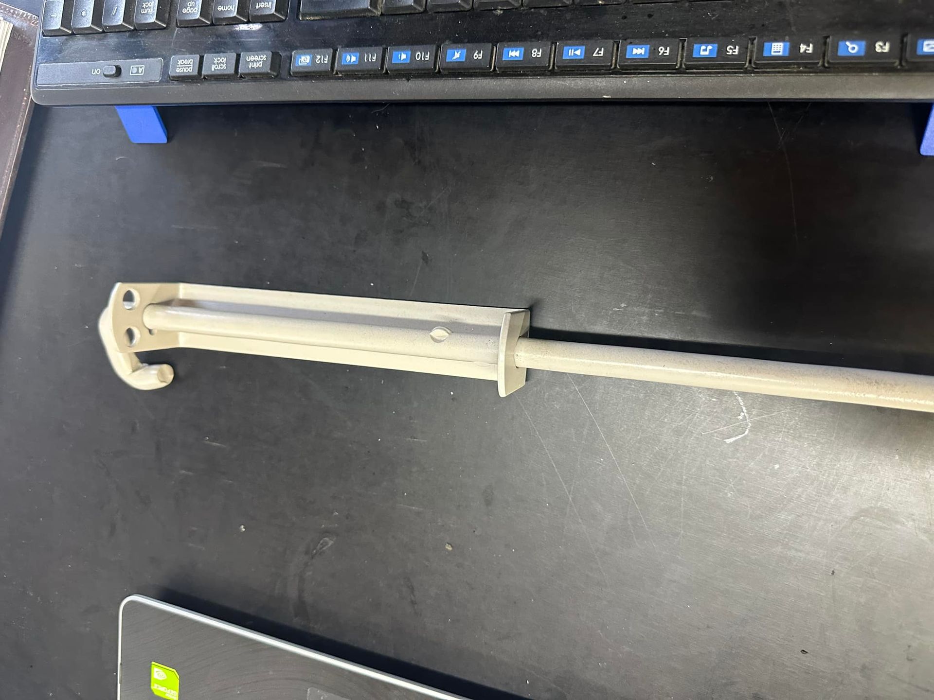 A Light-coloured, Mechanical Door Bolt on a Dark Surface, Near a Keyboard — Metal Fencing Supplies In Taree, NSW