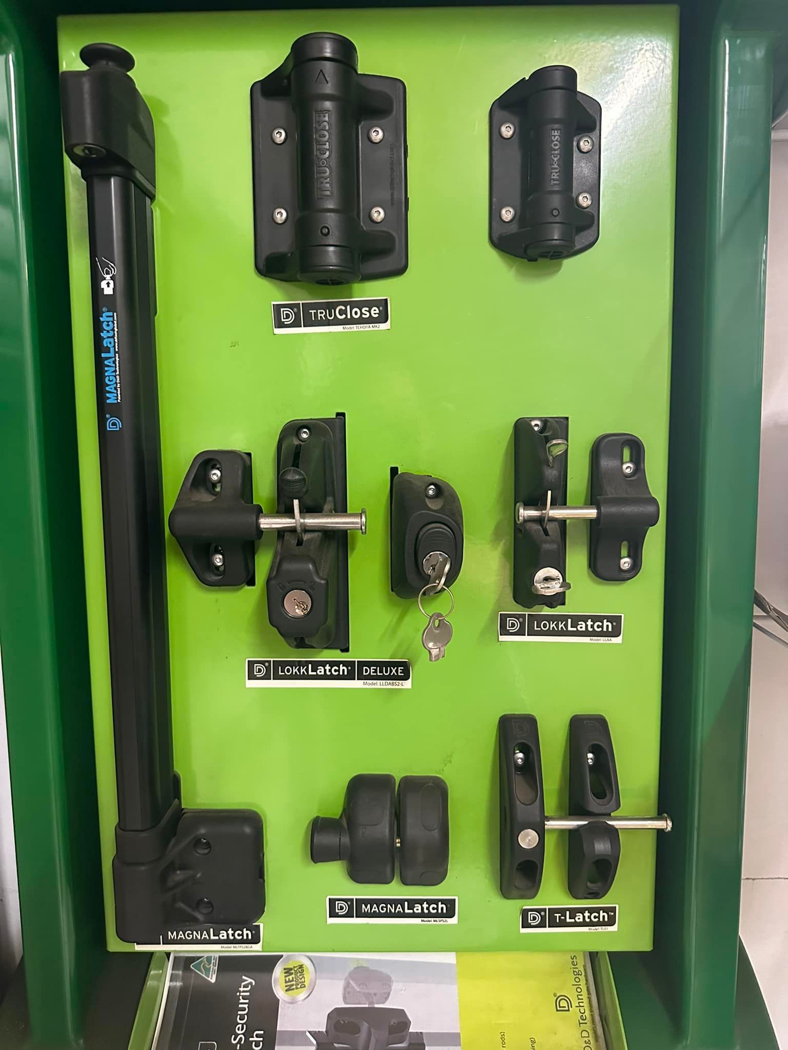 Display of Black Gate Hardware on a Green Board — Metal Fencing Supplies In Old Bar, NSW