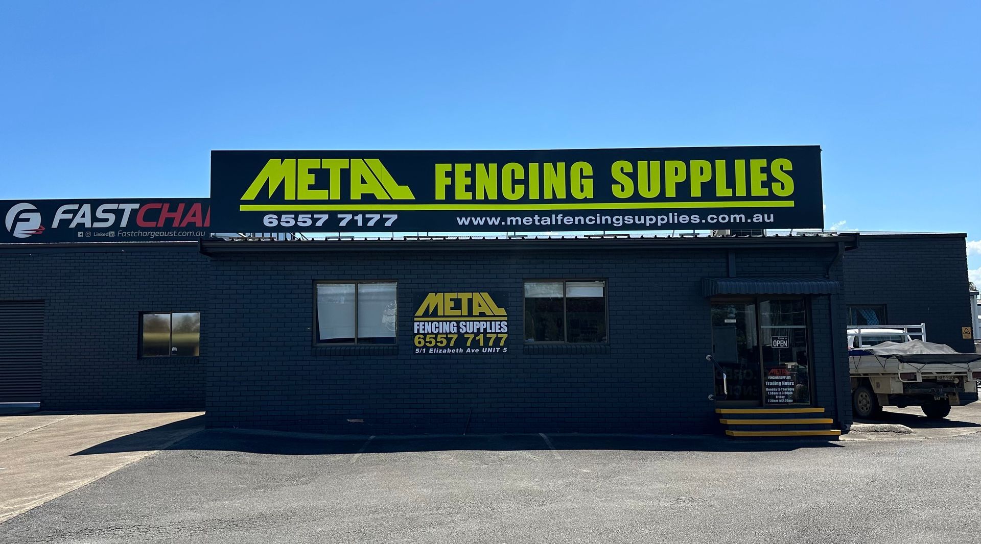 Metal Fencing Supplies store with black exterior, sign, and small office windows. — Metal Fencing Supplies In Taree, NSW