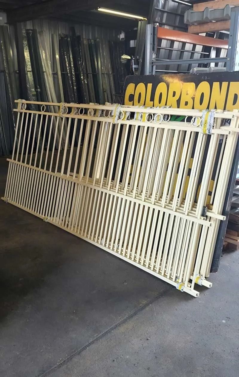 Stacks of Tan Metal Railing Sections in a Warehouse Setting — Metal Fencing Supplies In Wingham, NSW