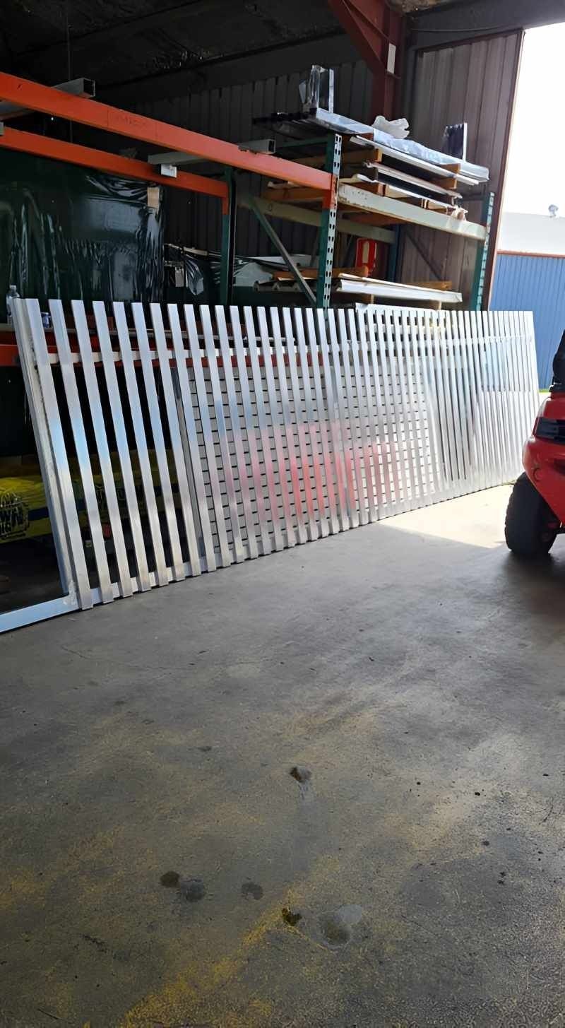 Metal Picket Fence Panel Leaning Against a Concrete Floor in a Warehouse — Metal Fencing Supplies In Forster, NSW